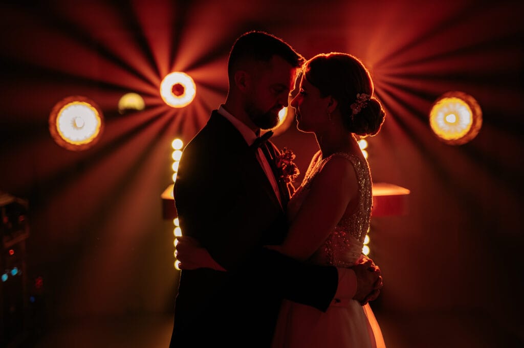 a man and woman in a dark room with lights -wedding. zdjęcia ze ślubu fotograf lublin