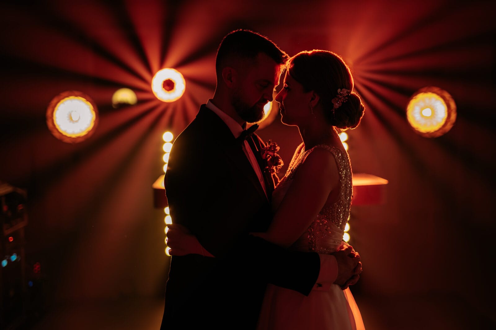 a man and woman in a dark room with lights -wedding. zdjęcia ze ślubu fotograf lublin