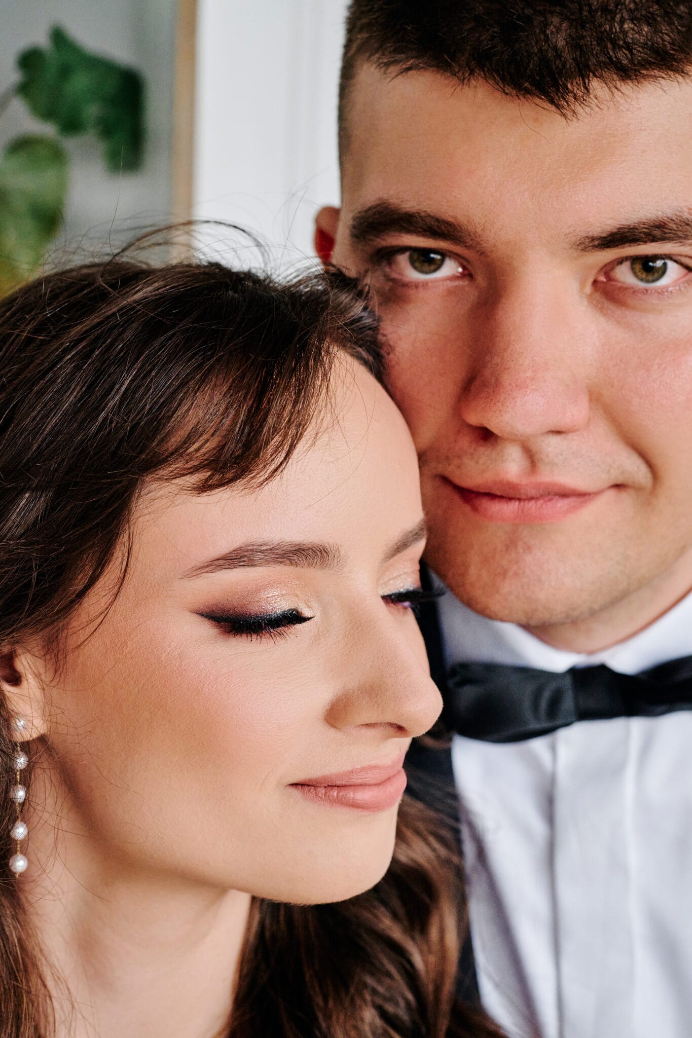 Agata i Radek na tle bujnej zieleni, spleceni w romantycznym objęciu. Idealne ujęcie podkreślające harmonię między parą a naturą. Słowa kluczowe: sesja ślubna w plenerze, romantyczne zdjęcia ślubne, zielona sceneria ślubna.