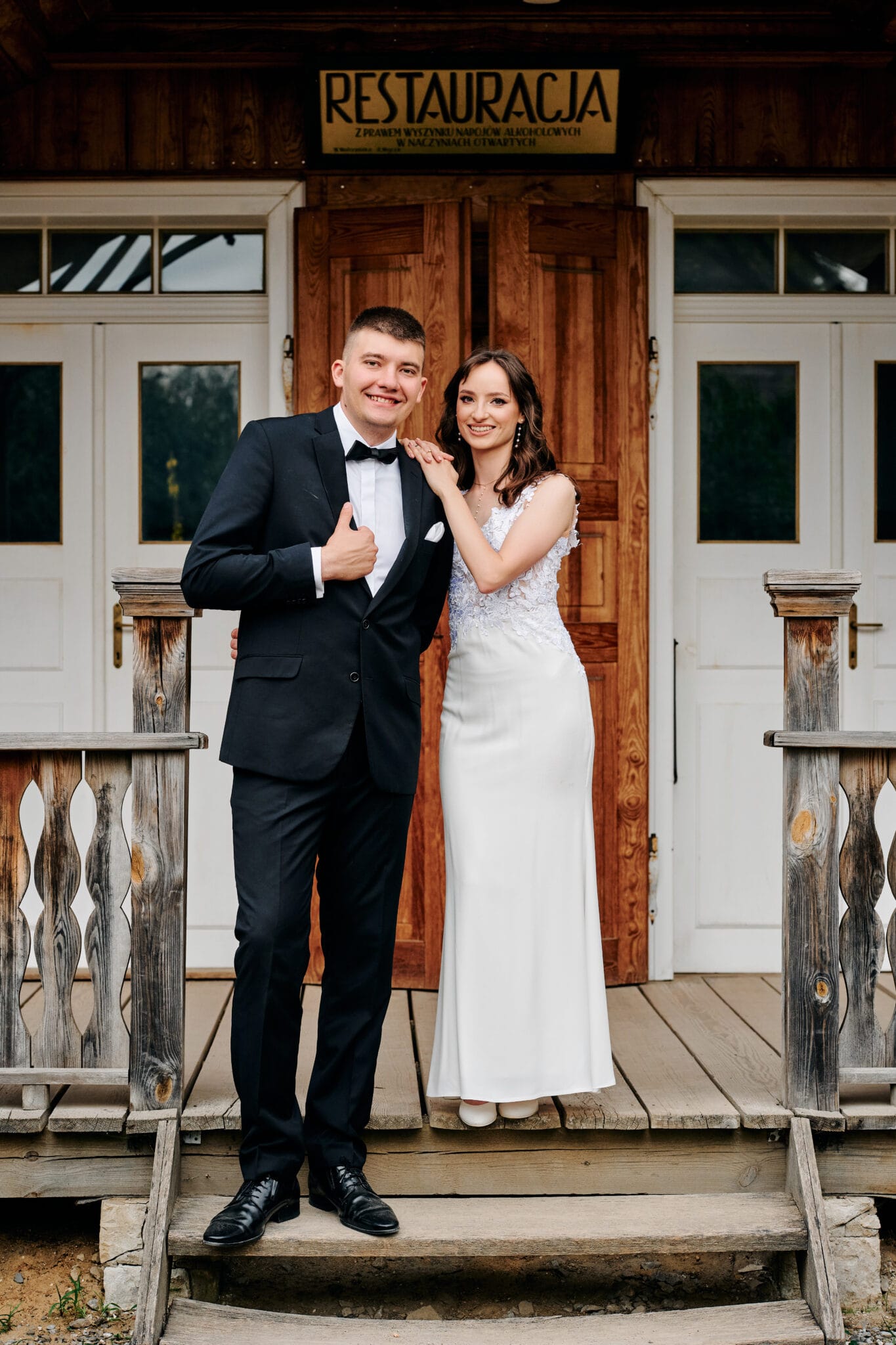 Agata i Radek na tle bujnej zieleni, spleceni w romantycznym objęciu. Idealne ujęcie podkreślające harmonię między parą a naturą. Słowa kluczowe: sesja ślubna w plenerze, romantyczne zdjęcia ślubne, zielona sceneria ślubna.